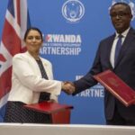 British Home Secretary Priti Patel (left), and Rwandan Foreign Minister Vincent Biruta, seal asylum seeker deal with a handshake. Photo by Simon Wohlfahrt/AFP via Getty Images