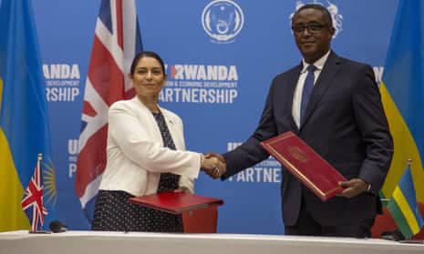 British Home Secretary Priti Patel (left), and Rwandan Foreign Minister Vincent Biruta, seal asylum seeker deal with a handshake. Photo by Simon Wohlfahrt/AFP via Getty Images